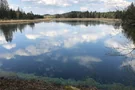 Die Wolken spiegeln sich im Mooshamer Weiher